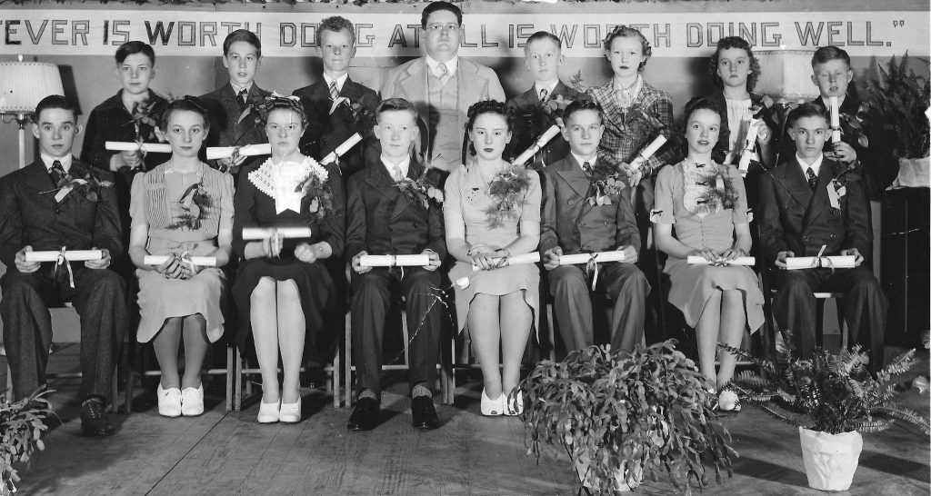 Two rows of kids posing with diplomas